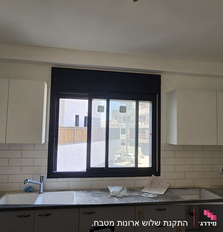 מטבח עם ארונות, כיור וברז מותקנים